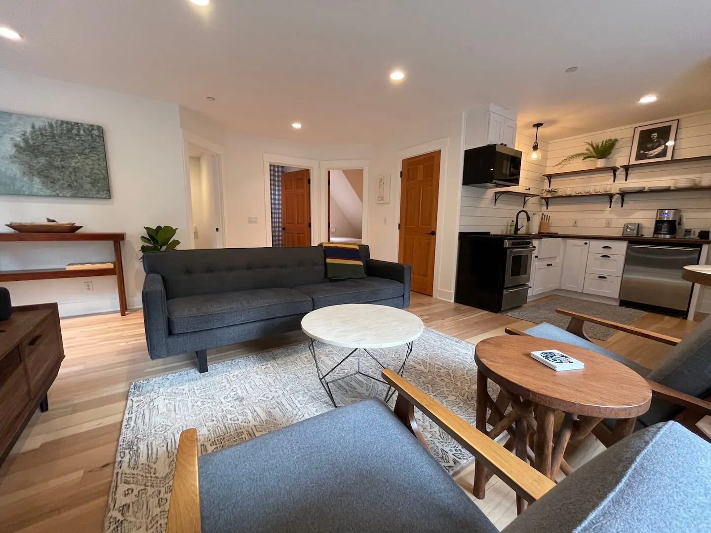 Bright living room with a sofa, armchairs and kitchenette in the Vashon carriage house