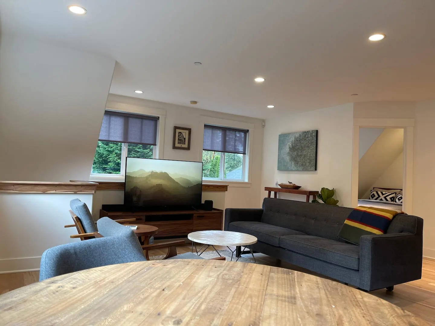 Living room with smart TV and a round dining table in the foreground