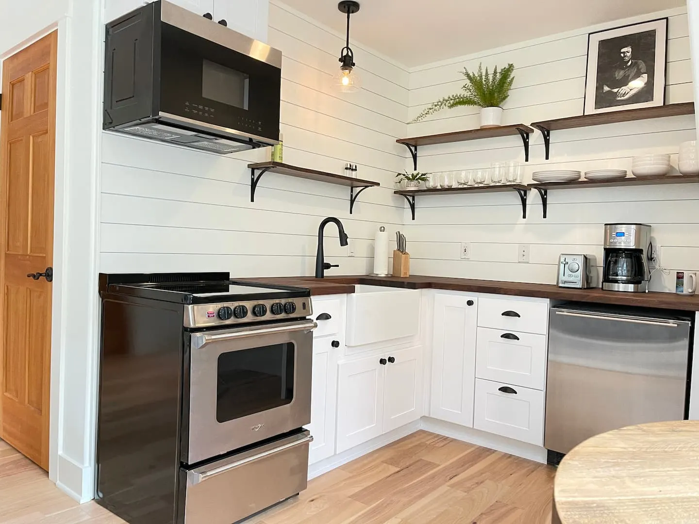 Fully equipped kitchen with open shelving, range and farmhouse sink