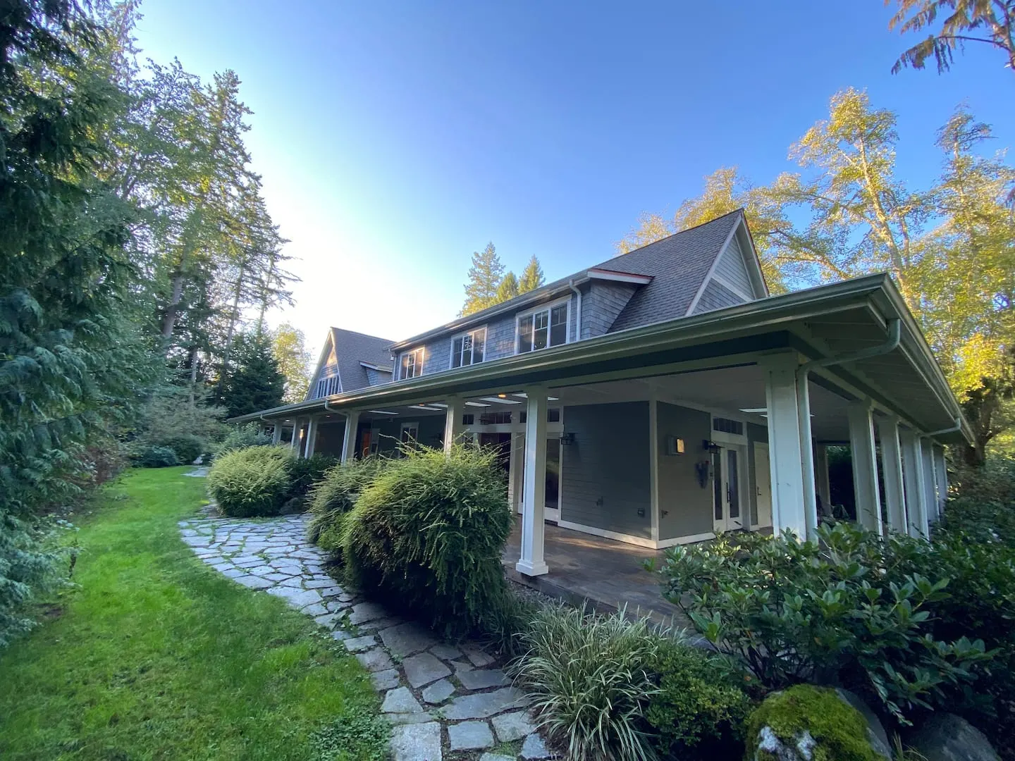 Exterior of the home with a covered porch and stone garden path on Vashon Island