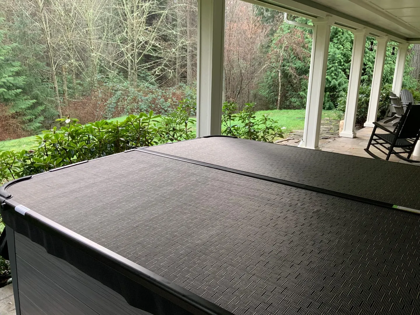 4-person hot tub on a covered porch beside the woods