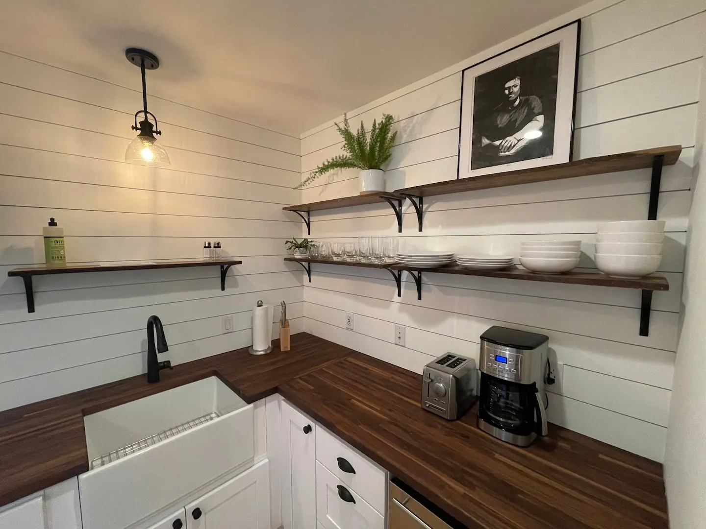 Kitchen counter with coffee maker, toaster and open shelves of dishes