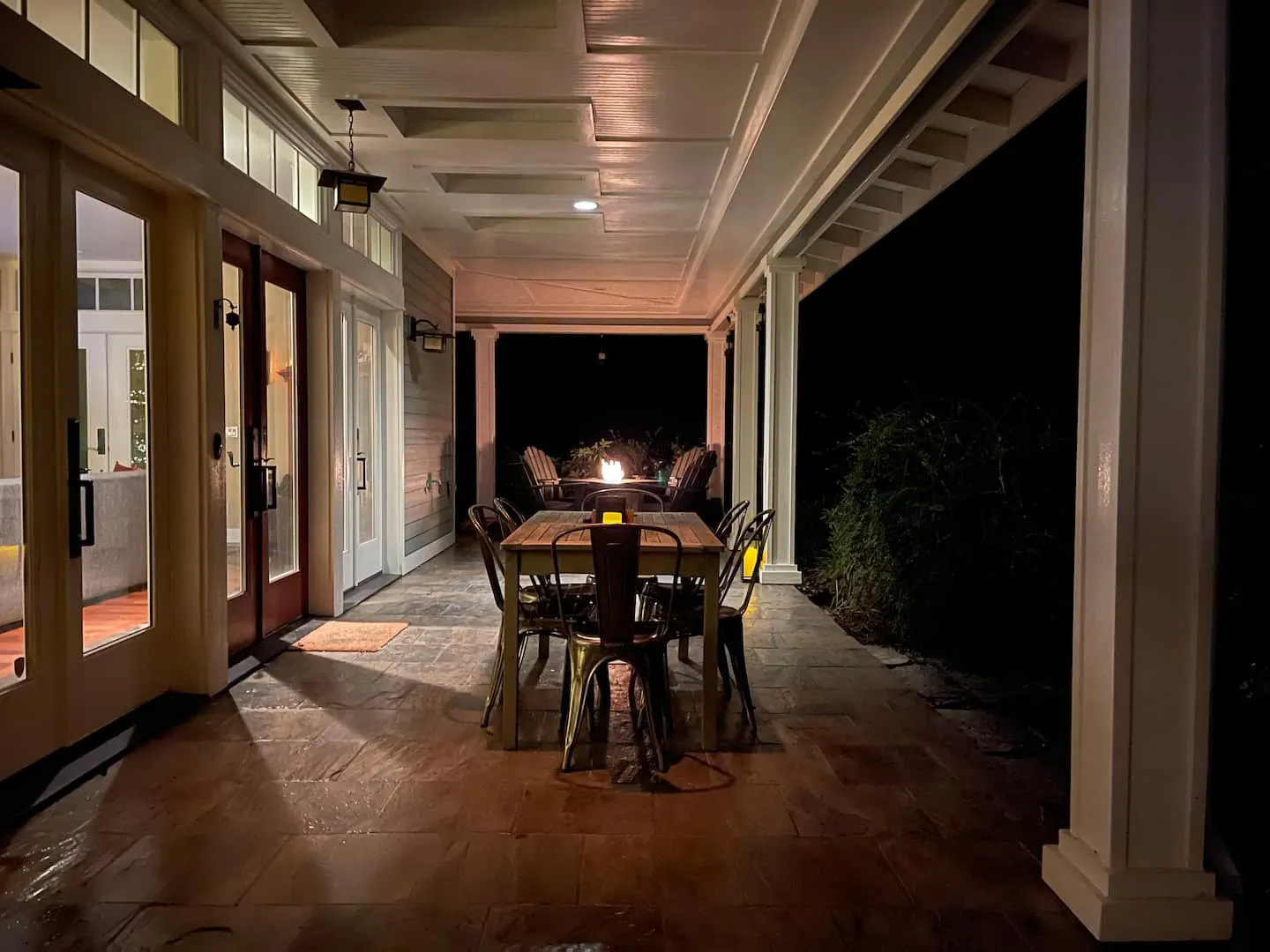 Covered patio dining area lit in the evening