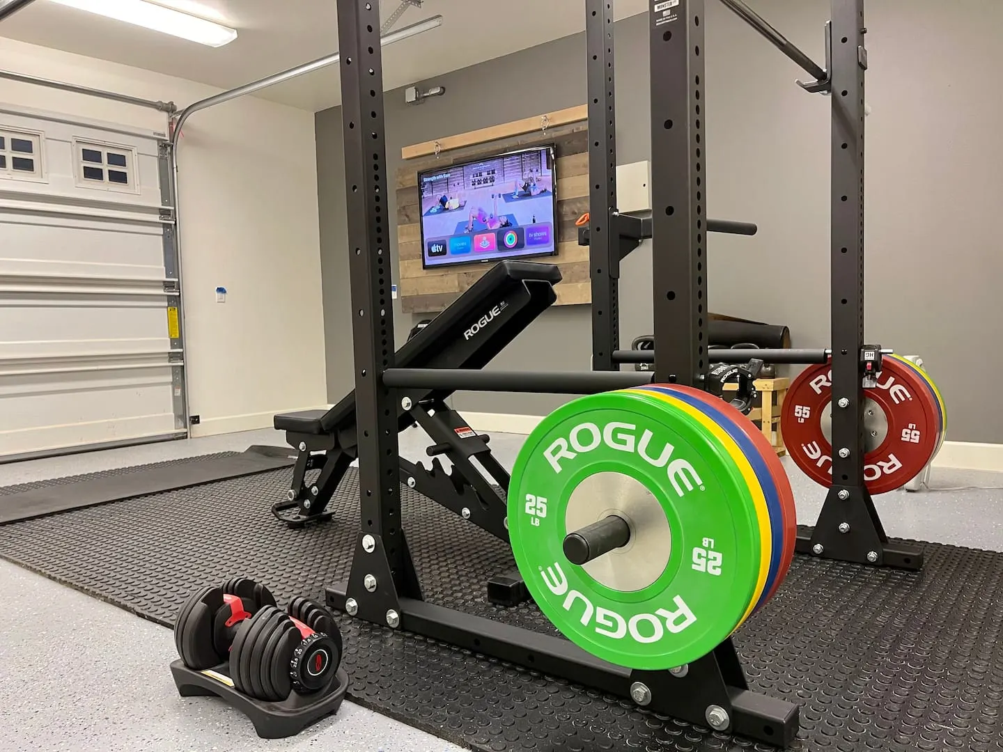 Guest gym with Rogue Olympic weight rack, rower and adjustable dumbbells